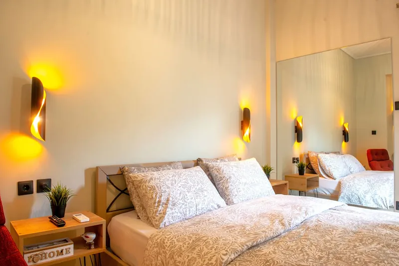 The double bed with patterned linen and wall lights