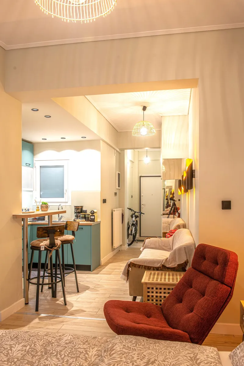 The living room with the red velvet armchair, looking to the kitchen