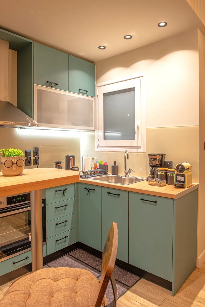 The teal kitchen cabinets and the window