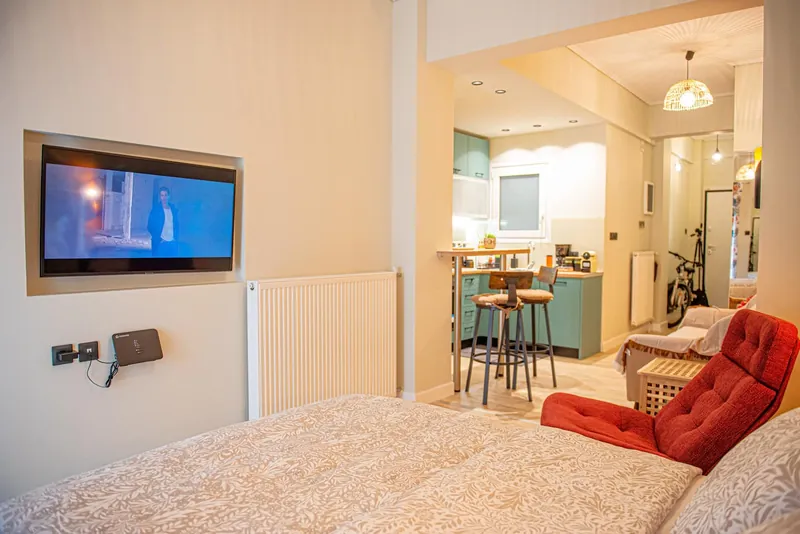 The wall TV, the armchair and the kitchen bar